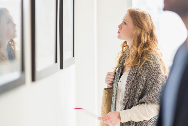 Female Millennial admiring artwork in gallery 