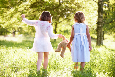 Children walking with a teddy bear